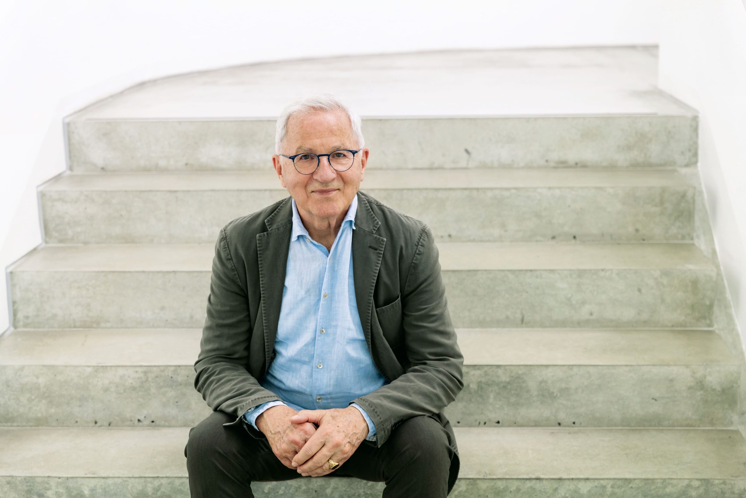 Dr. Jürgen Kässer, analytischer Coach und Unternehmensberater für den Mittelstand, sitzt auf einer modernen Betontreppe und vermittelt Ruhe, Präsenz und professionelle Begleitung für Unternehmer und Führungskräfte.